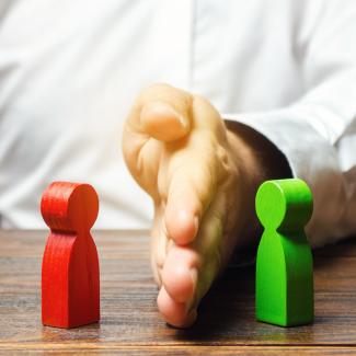 A hand separating two people figures