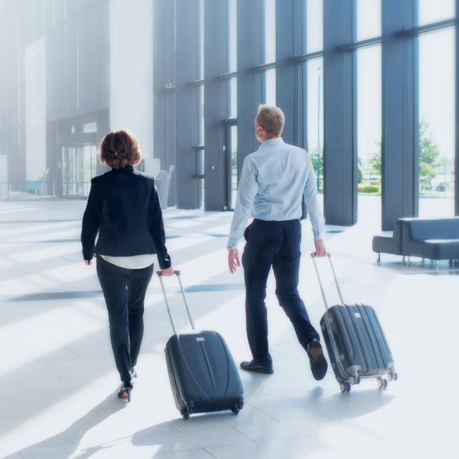 Two people with luggage walking in an airport